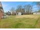 Spacious backyard featuring a shed, with mature trees in the distance at 324 Dare St, Burlington, NC 27217