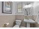Neutral half bathroom featuring a pedestal sink, toilet, and decorative mirror at 3424 English Cir, Willow Springs, NC 27592
