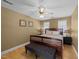 Comfortable bedroom with a wooden bed frame, ceiling fan and a dark gray bench at 3424 English Cir, Willow Springs, NC 27592