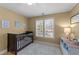 Cozy Bedroom room with a dark wooden crib, plush carpet, and natural light at 3424 English Cir, Willow Springs, NC 27592