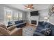Cozy living room featuring a fireplace, comfortable blue sofas, and hardwood flooring at 3424 English Cir, Willow Springs, NC 27592