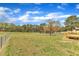 Expansive backyard with a deck, lush green grass, and mature trees offering ample space and privacy at 3533 N Way Dr, Zebulon, NC 27597