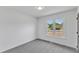 This bedroom has gray carpet, white walls and a window with a view of the yard at 3533 N Way Dr, Zebulon, NC 27597