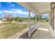 Covered front porch with a white railing that overlooks the lush green lawn at 3533 N Way Dr, Zebulon, NC 27597