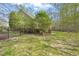 View of home's back exterior showcasing lawn, trees, and black metal fence around the property at 367 Windham Way, Clayton, NC 27527