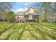 View of house back exterior showing deck and backyard lawn with trees at 367 Windham Way, Clayton, NC 27527
