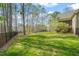Spacious backyard with a metal fence and lush green grass surrounded by bare trees at 367 Windham Way, Clayton, NC 27527