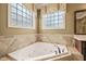 Bathroom featuring a soaking tub with tile surround and windows for natural light at 367 Windham Way, Clayton, NC 27527