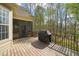 Outdoor deck with dark grill under a black cover with screened windows and trees in the background at 367 Windham Way, Clayton, NC 27527