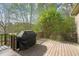 Outdoor deck with a dark grill under a black cover and trees in the background at 367 Windham Way, Clayton, NC 27527