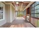 Spacious covered porch featuring wood flooring, ceiling fans, and screened windows at 367 Windham Way, Clayton, NC 27527