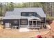 Back exterior of a house with an open patio, screened porch, and lush green backyard at 370 Chapel Ridge Dr, Pittsboro, NC 27312