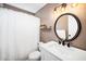 Neutral bathroom with white vanity, round mirror, stylish lighting, and shower with curtain at 3708 Turnbull Ct, Raleigh, NC 27616