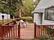Well-maintained deck featuring a table with chairs and an umbrella overlooking the backyard at 3711 Halford Dr, Raleigh, NC 27604