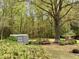 A tranquil backyard with seating area, shed and mature trees at 3711 Halford Dr, Raleigh, NC 27604