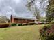 Spacious backyard featuring lush greenery, mature trees and brick exterior at 3711 Halford Dr, Raleigh, NC 27604