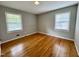 Bright bedroom featuring hardwood floors, neutral walls, and two windows for natural light at 3711 Halford Dr, Raleigh, NC 27604