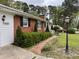 Charming brick home featuring mature landscaping, black shutters, and a welcoming brick walkway at 3711 Halford Dr, Raleigh, NC 27604