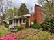 Landscaped home exterior featuring a brick chimney and an ornamental fountain at 3711 Halford Dr, Raleigh, NC 27604