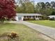 Charming brick home features a well-manicured lawn, a basketball hoop, and a long driveway at 3711 Halford Dr, Raleigh, NC 27604