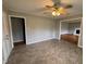 Spacious living room with ceiling fan and view to another room; built-in cupboard on the left side at 3711 Halford Dr, Raleigh, NC 27604