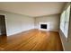 Bright living room featuring hardwood floors, a brick fireplace, and a large window at 3711 Halford Dr, Raleigh, NC 27604