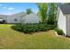 Well-manicured lawn with lush green bushes, complementing the home's pristine white exterior and attached garage at 374 Ashley Woods Ct, Clayton, NC 27527