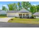 Charming single-story home with a manicured lawn, a covered front porch, and an attached two car garage at 374 Ashley Woods Ct, Clayton, NC 27527