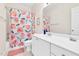 Bright bathroom showcasing a vanity with white cabinets and a peach-themed shower curtain at 4 Scottish Ln, Durham, NC 27707