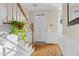 Light-filled foyer with hardwood floors, paneled walls, and a staircase with decorative plant at 4 Scottish Ln, Durham, NC 27707