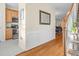 Hallway showcasing hardwood floors, paneled walls, and the kitchen with stainless steel appliances at 4 Scottish Ln, Durham, NC 27707