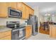 Kitchen showcasing stainless steel appliances, granite countertops, and natural wood cabinetry at 4 Scottish Ln, Durham, NC 27707