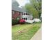 Condo exterior features latticework balcony, white picket fence, and well maintained lawn at 411 Gooseneck Drive # B6, Cary, NC 27513