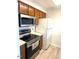 Kitchen featuring wood cabinets, stainless steel microwave, and white refrigerator at 411 Gooseneck Drive # B6, Cary, NC 27513