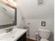 Clean bathroom featuring a large square decorative mirror and a white toilet at 4217 Pike Rd, Raleigh, NC 27613