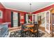 Elegant dining room featuring bold red walls, hardwood floors, chandelier, and classic decor, perfect for entertaining at 4217 Pike Rd, Raleigh, NC 27613