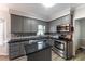 Stylish kitchen boasts gray cabinets, granite countertops, stainless steel appliances, and a functional island, great for cooking at 4217 Pike Rd, Raleigh, NC 27613