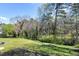 Spacious backyard featuring lush green lawn and mature trees, providing a serene outdoor setting at 4308 James Rd, Raleigh, NC 27616