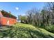 Brick home featuring a spacious backyard with a sloped lawn and partial wooded area at 4308 James Rd, Raleigh, NC 27616