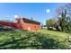 Brick home with a large sloped backyard featuring mature trees, providing a private outdoor space at 4308 James Rd, Raleigh, NC 27616