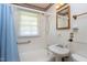 Bright bathroom with a shower-tub combo and pedestal sink at 4308 James Rd, Raleigh, NC 27616