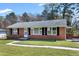 Traditional brick home featuring a well-manicured lawn, concrete walkway, and charming facade at 4308 James Rd, Raleigh, NC 27616