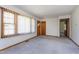 Bright living room with neutral carpet, large window with blinds, and classic wood trim at 4308 James Rd, Raleigh, NC 27616