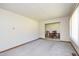 Spacious living room with neutral carpet, baseboard trim, and an opening to the dining area at 4308 James Rd, Raleigh, NC 27616