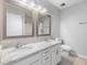 Updated bathroom with dual vanities, granite countertops, modern fixtures, and a large framed mirror at 5 Maidenhair Ct, Durham, NC 27703