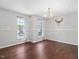 Spacious dining room featuring hardwood floors, natural light from windows, and a stylish chandelier at 5 Maidenhair Ct, Durham, NC 27703