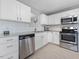 Kitchen featuring stainless appliances, ample granite countertops, and white cabinets, offering a clean and modern aesthetic at 5 Maidenhair Ct, Durham, NC 27703