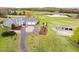 Expansive aerial view of the property featuring a home, pond, barn, and manicured lawn at 500 Walnut Hill Dr, Hillsborough, NC 27278