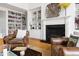 Bright living room featuring a fireplace, built-in bookshelves, and hardwood floors at 500 Walnut Hill Dr, Hillsborough, NC 27278