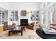 Bright living room featuring a fireplace, built-in bookshelves, hardwood floors, and large windows at 500 Walnut Hill Dr, Hillsborough, NC 27278